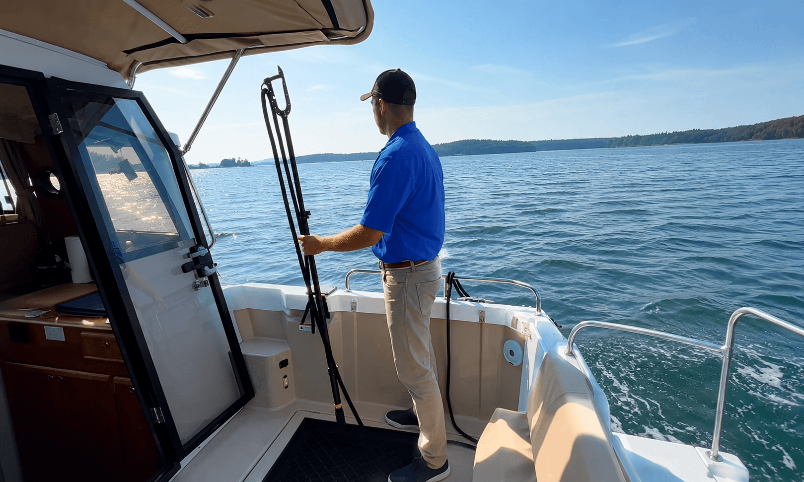 Boater standing at the stern of a boat looking out over the water