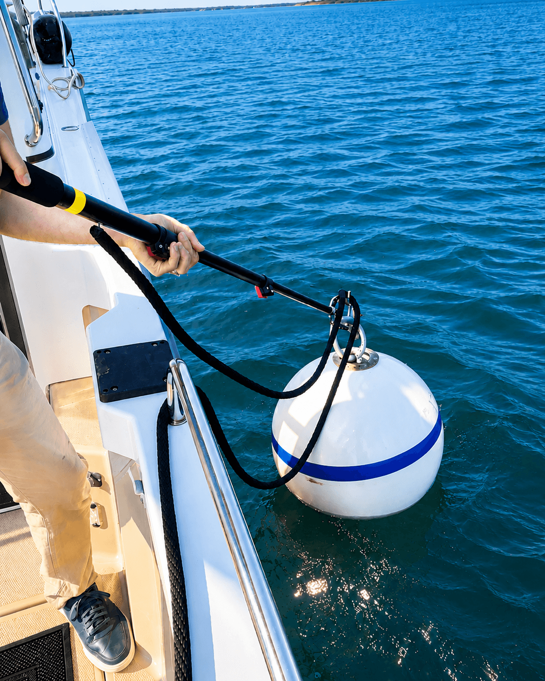 Boater grabbing a mooring buoy from the deck using the Buoycatcher Max